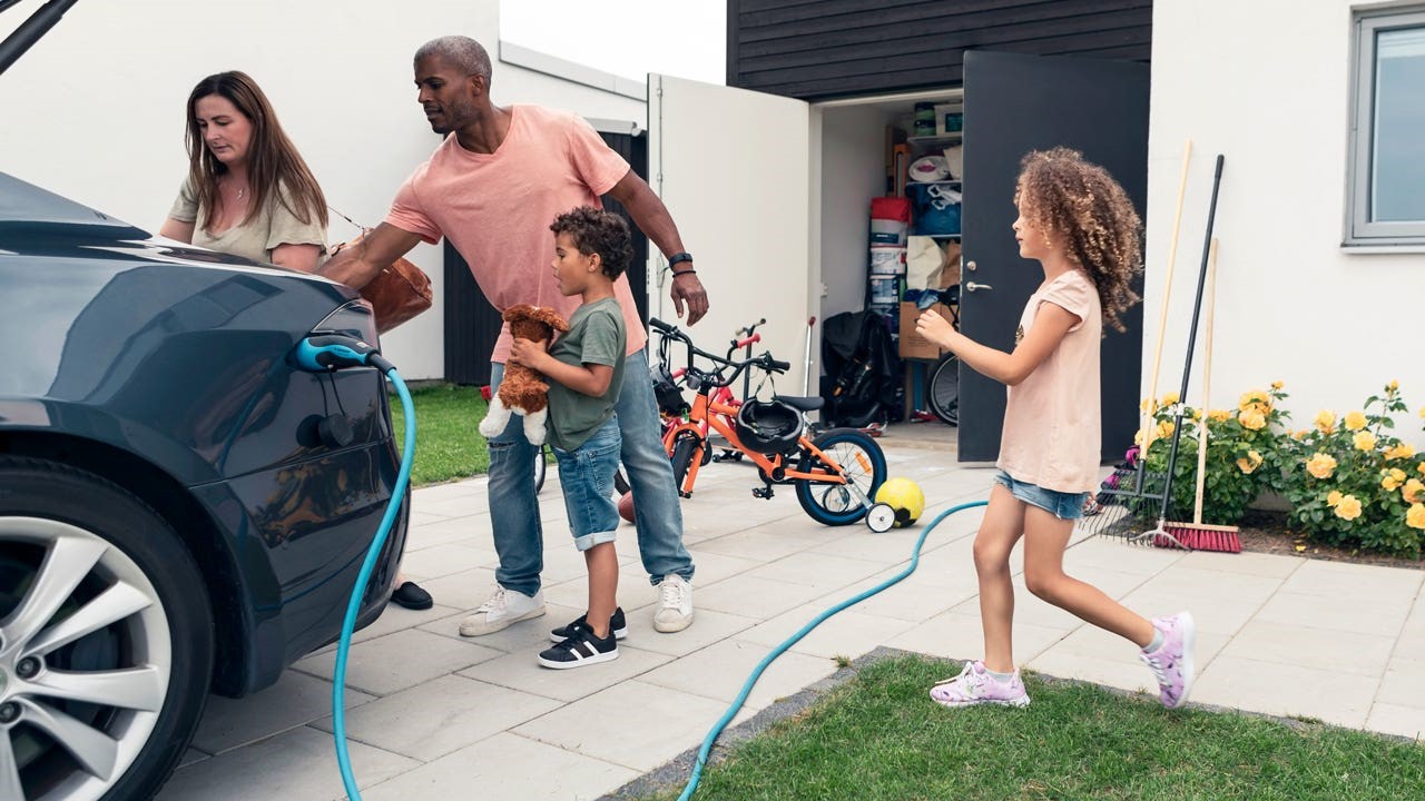 Family loading up electric car while its being charged