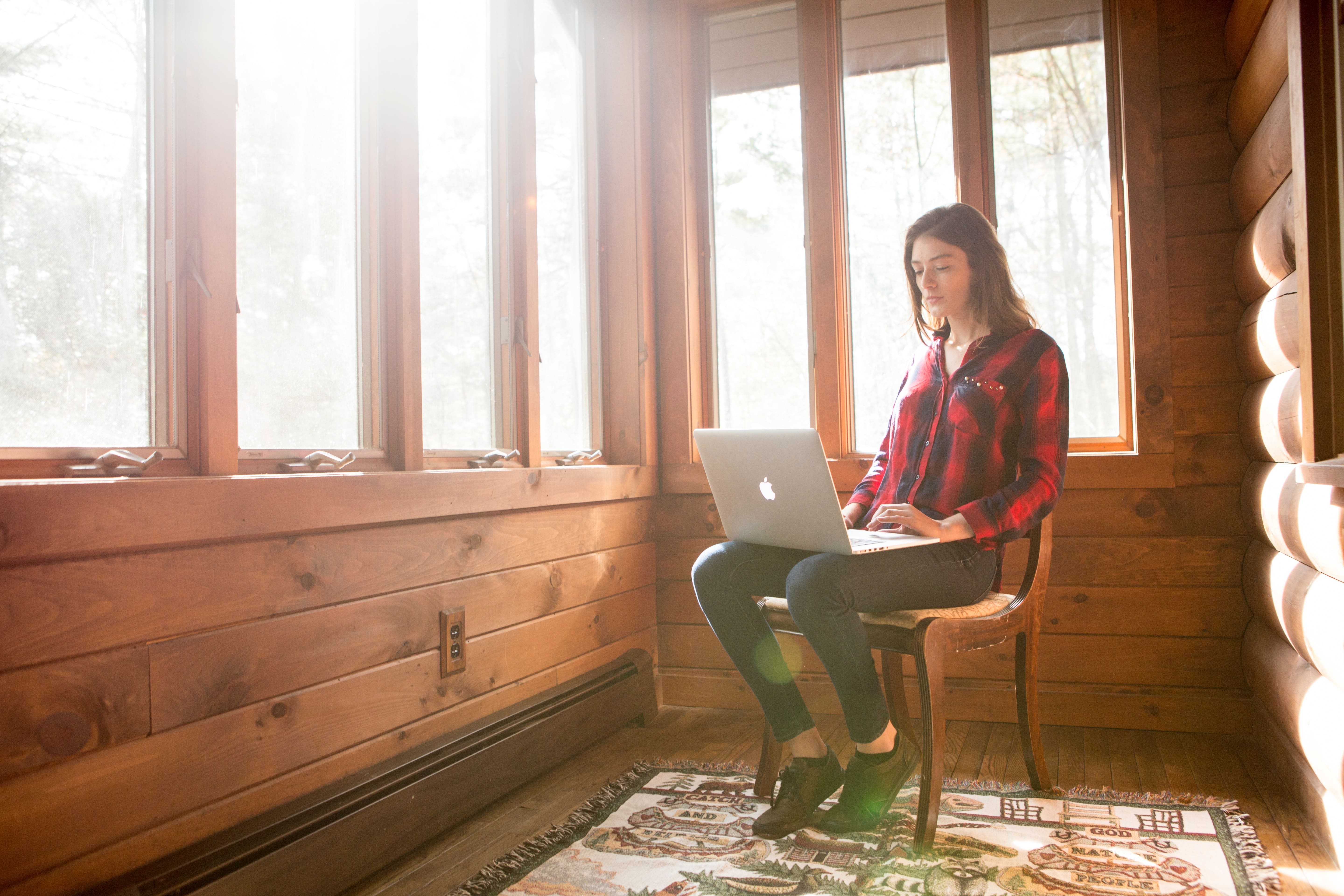 woman working on a laptop sitting in a chair 